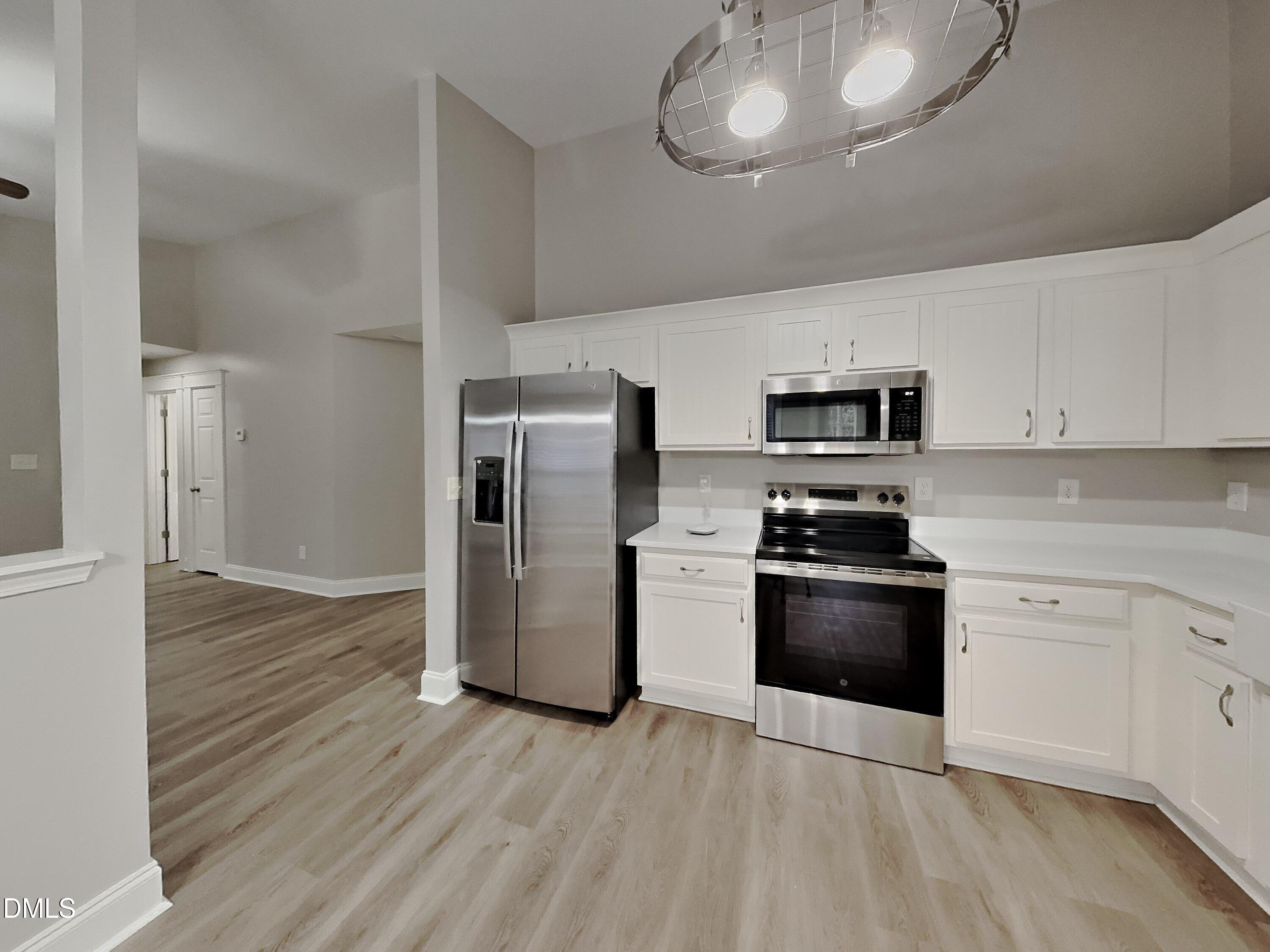3665 Watkins Ridge Court Raleigh, NC 27616 - Photo 4 of 15 a kitchen with stainless steel appliances granite countertop a refrigerator stove and white cabinets