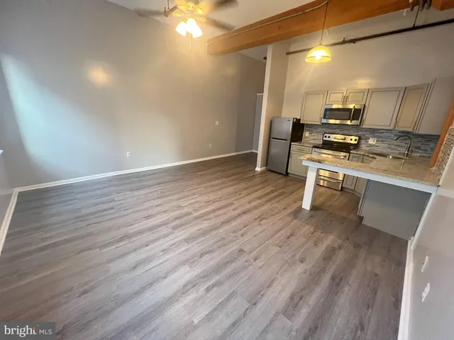 a view of a kitchen with wooden floor and electronic appliances