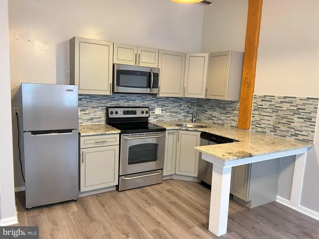 a kitchen with a stove refrigerator and microwave
