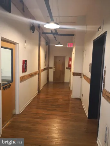 a view of a refrigerator in kitchen and an empty room