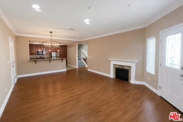 a view of empty room with wooden floor and fireplace