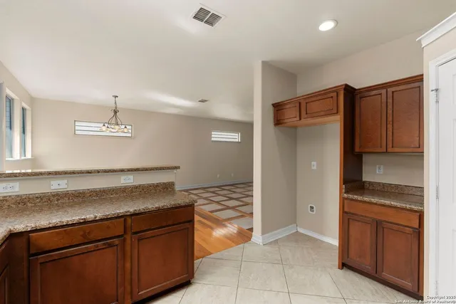 a kitchen with granite countertop a refrigerator and a sink