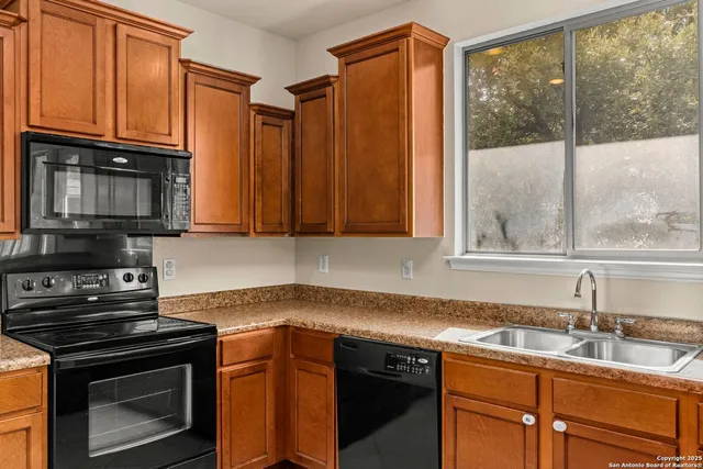 a kitchen with stainless steel appliances granite countertop a stove a sink and a microwave