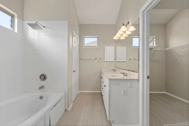 a bathroom with a tub sink and mirror