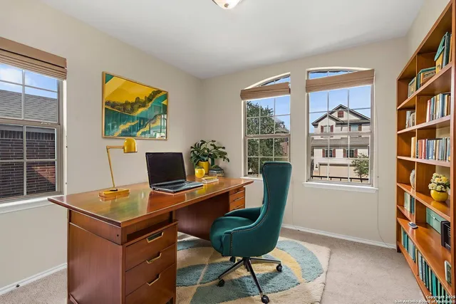 a view of a workspace with furniture and a window