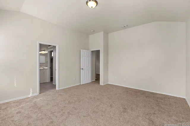 a view of an empty room with closet and a window