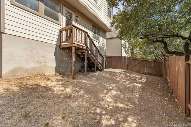 a view of a yard with wooden fence