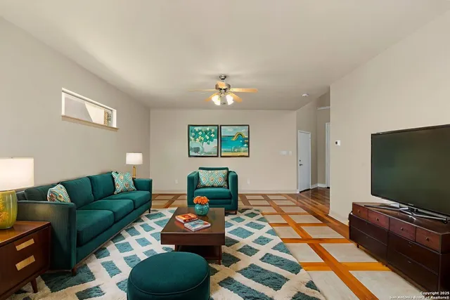 a living room with furniture a flat screen tv and a window