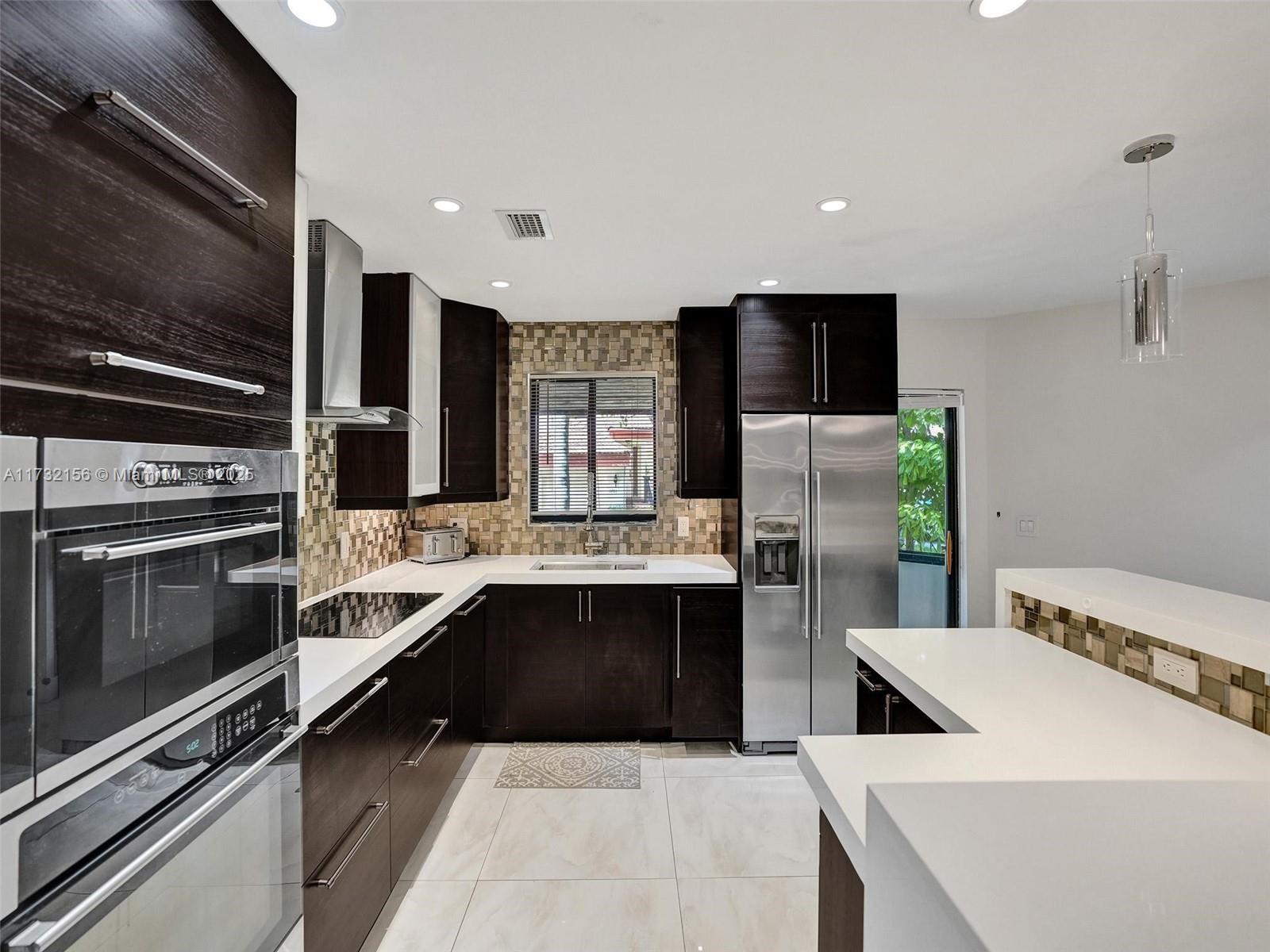 3507 Green Leaf Circle, Unit 2004 Hollywood, FL 33021 - Photo 9 of 33 a kitchen with stainless steel appliances kitchen island granite countertop a sink and a stove