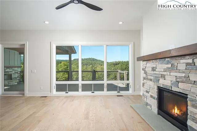 a view of an empty room with a fireplace and a window