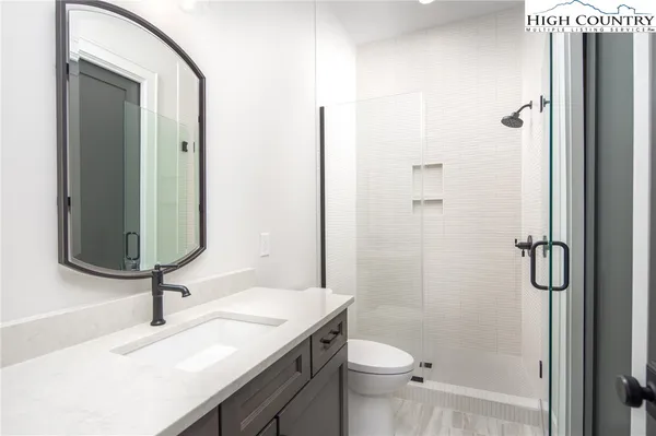 a bathroom with a sink a toilet and shower