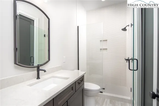 a bathroom with a sink a toilet and shower