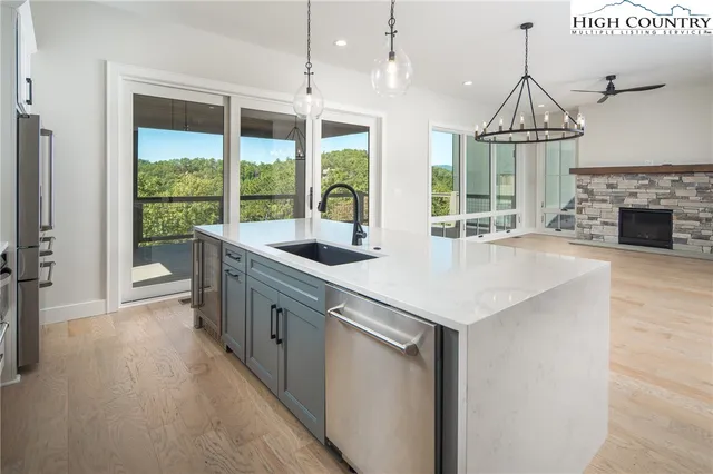 a kitchen with stainless steel appliances granite countertop a stove and a wooden floors