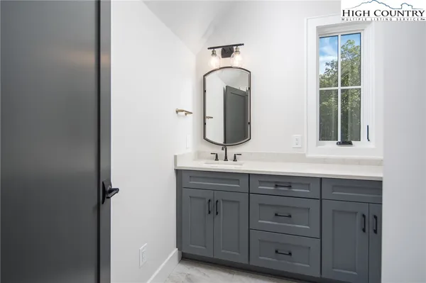 a bathroom with a sink and two mirror