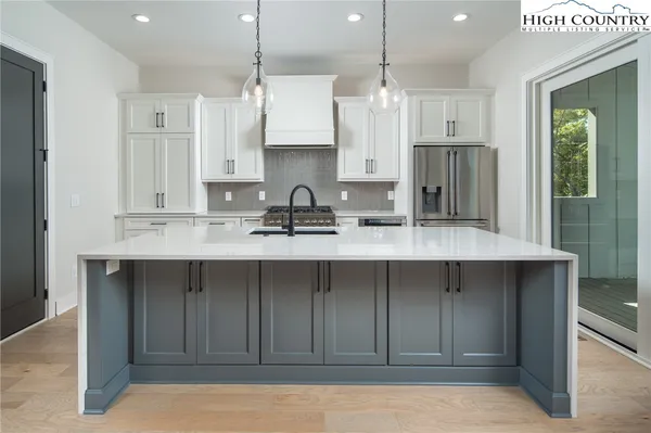 a kitchen with stainless steel appliances a sink stove and refrigerator