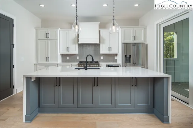 a kitchen with stainless steel appliances a sink stove and refrigerator