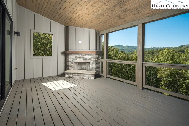 a view of a room with wooden floor a fireplace and windows