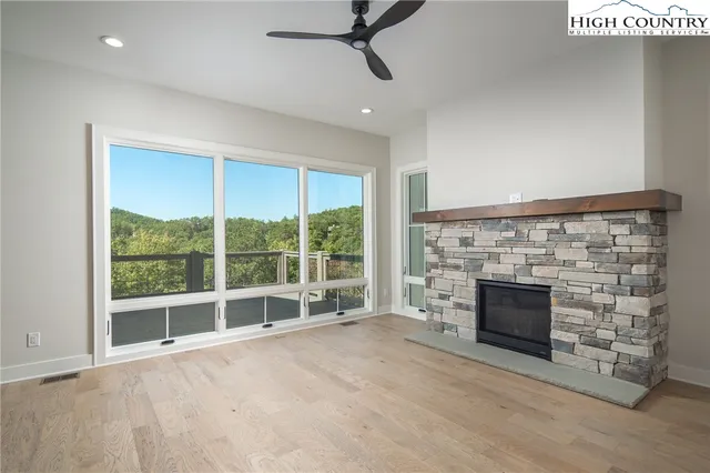 wooden floor fireplace and windows in an empty room