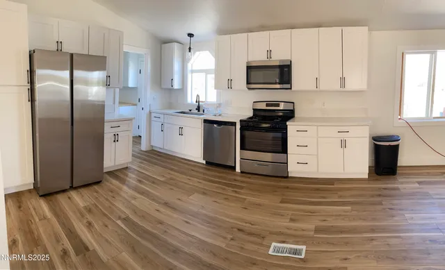 a kitchen with granite countertop a refrigerator stove top oven and sink