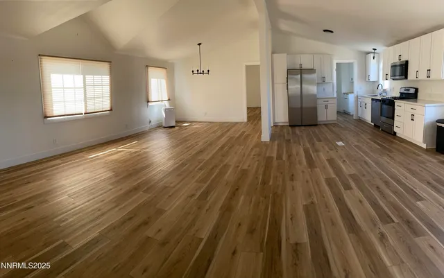 a view of empty room with wooden floor and window
