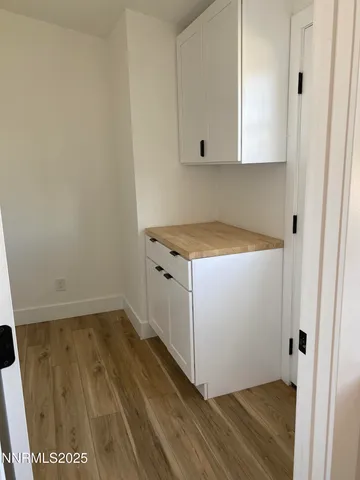 a utility room with wooden floor washer and dryer