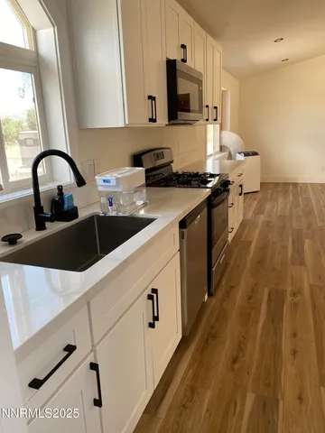 a kitchen with kitchen island granite countertop a sink appliances cabinets and a counter top space