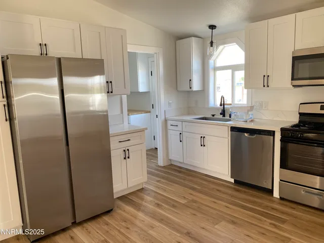 a kitchen with stainless steel appliances a refrigerator sink and microwave