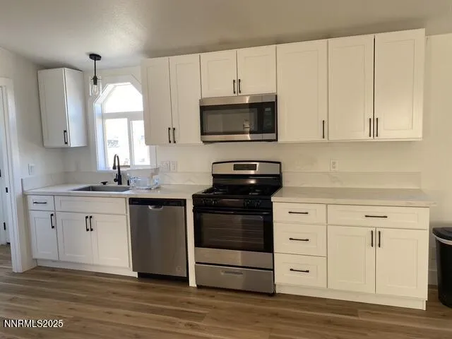 a kitchen with granite countertop white cabinets and stainless steel appliances