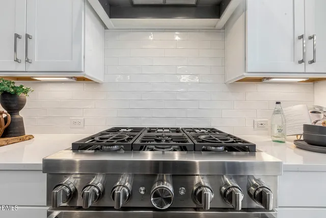 a kitchen with stainless steel appliances kitchen island granite countertop a table chairs and a kitchen view