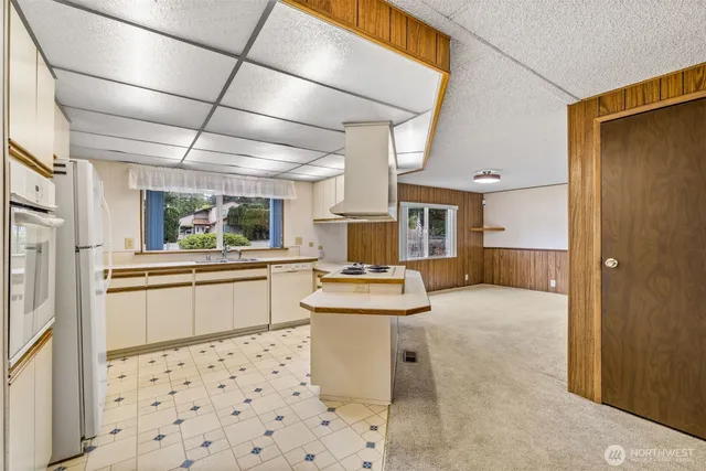 a kitchen with a refrigerator a stove a sink dishwasher and wooden cabinets