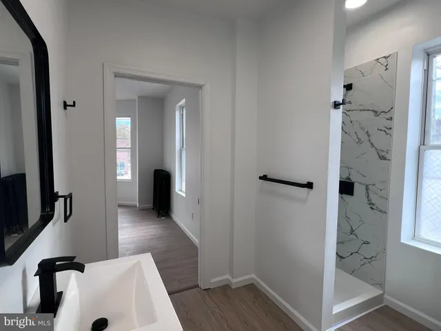 a view of a hallway with wooden floor and a living room