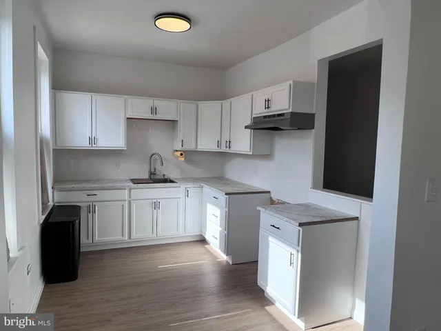 a kitchen with granite countertop a sink cabinets and stainless steel appliances