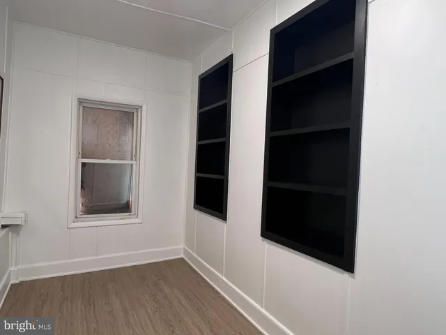 an empty room with wooden floor and closet