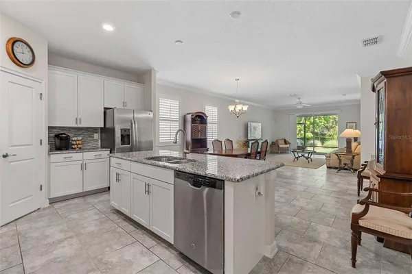 a kitchen with stainless steel appliances granite countertop a sink stove refrigerator and cabinets