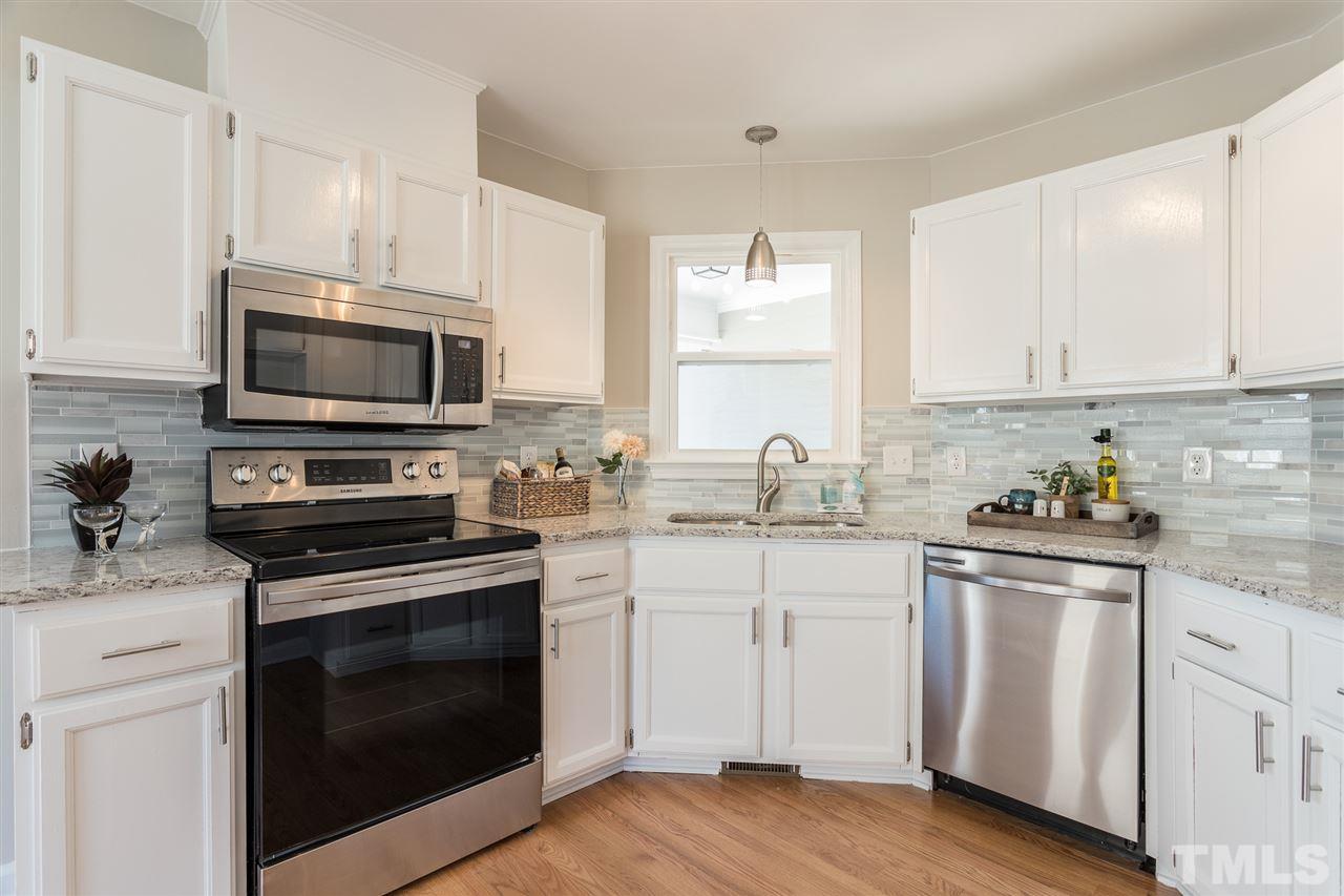 4556 Birmingham Way Raleigh, NC 27604 - Photo 2 of 24 a kitchen with cabinets stainless steel appliances a sink and a stove