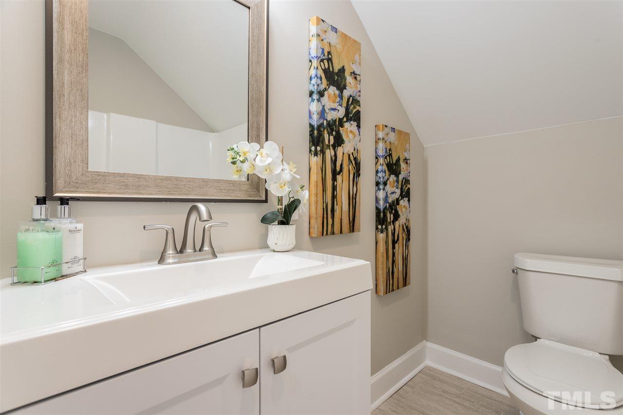 4556 Birmingham Way Raleigh, NC 27604 - Photo 19 of 24 a bathroom with a sink a toilet and a mirror