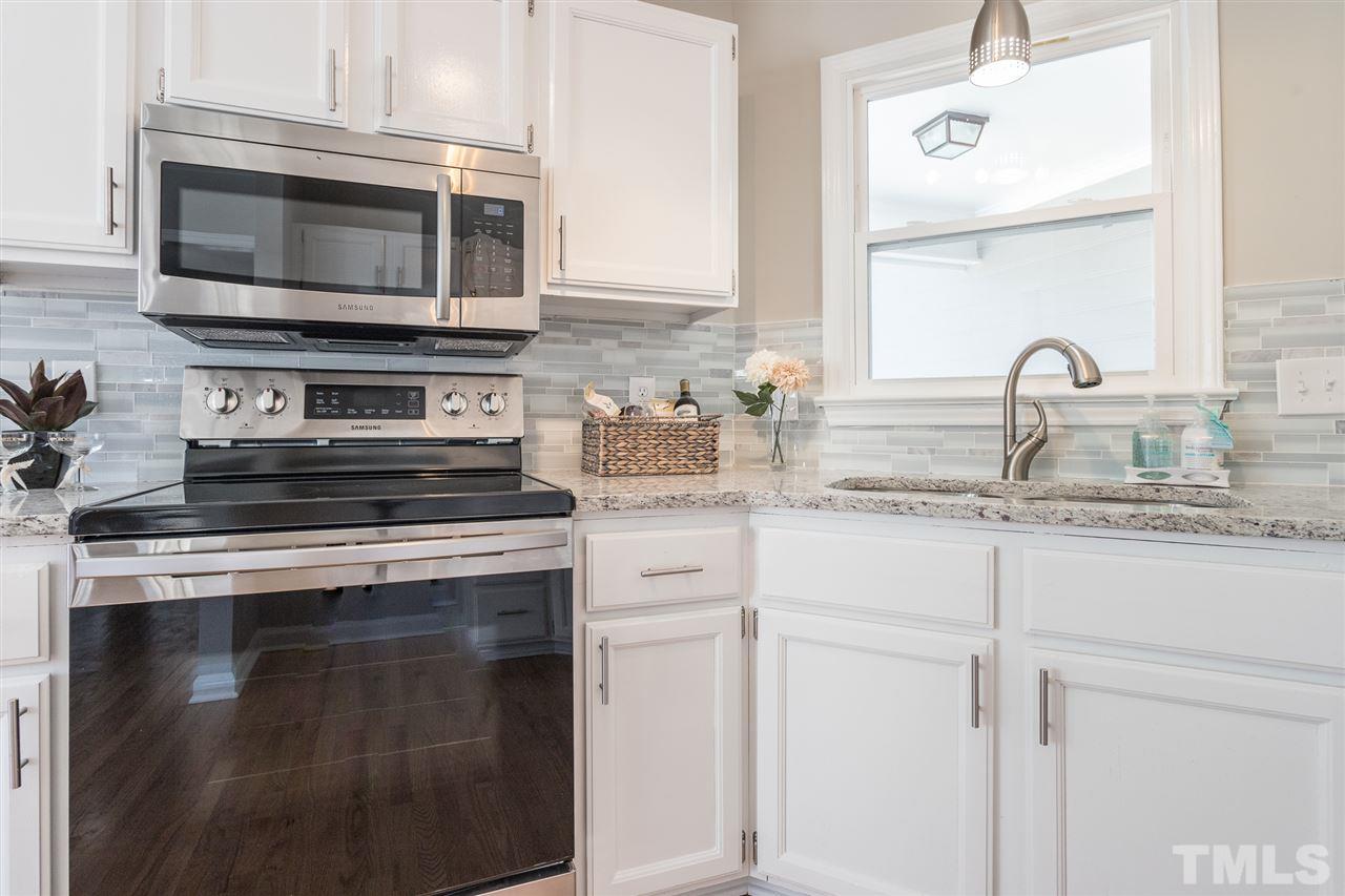 4556 Birmingham Way Raleigh, NC 27604 - Photo 7 of 24 a kitchen with granite countertop white cabinets stainless steel appliances and a sink