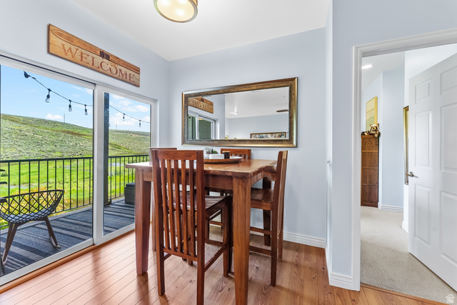 900 Bitner Road, Unit K25 Park City, UT 84098 - Photo 12 of 35 Sliding glass doors opening to a private balcony with black metal railing, offering expansive views of a natural green hillside