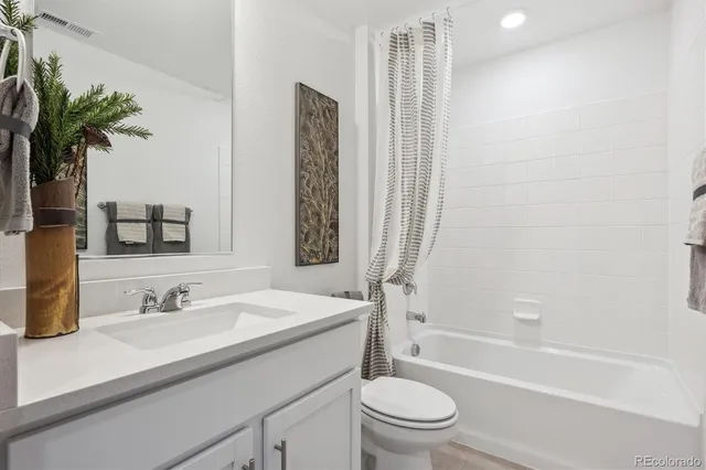 a bathroom with a granite countertop sink a toilet and tub