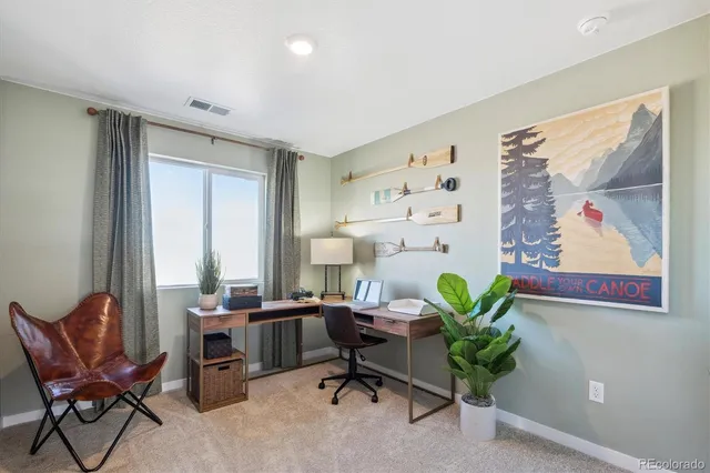 a view of a workspace with furniture and a window