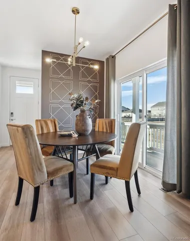 a dining room with furniture a chandelier and wooden floor