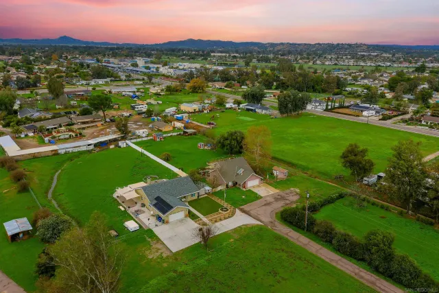 an aerial view of residential houses with outdoor space and trees