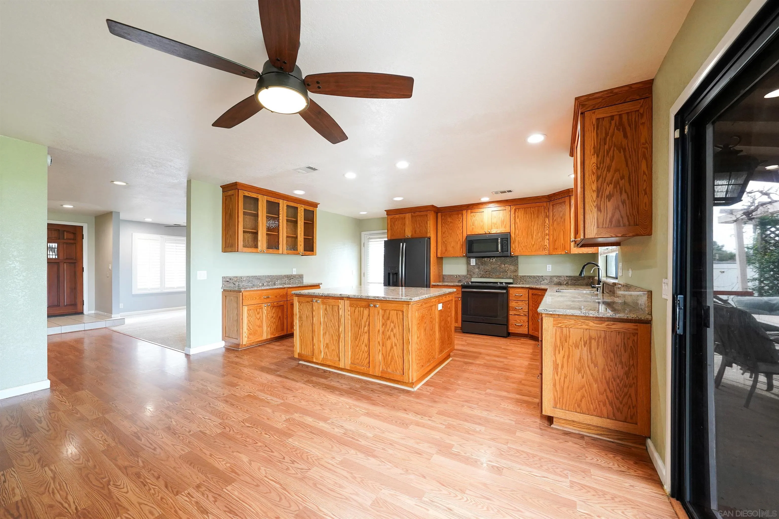 1465 Barnett Road Ramona, CA 92065 - Photo 18 of 43 a kitchen with stainless steel appliances kitchen island granite countertop a refrigerator a sink a stove and oven with wooden floor