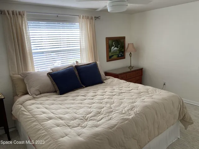 a bedroom with a large bed and a window