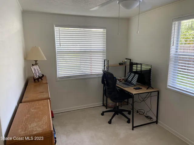 a view of a workspace with furniture and a window