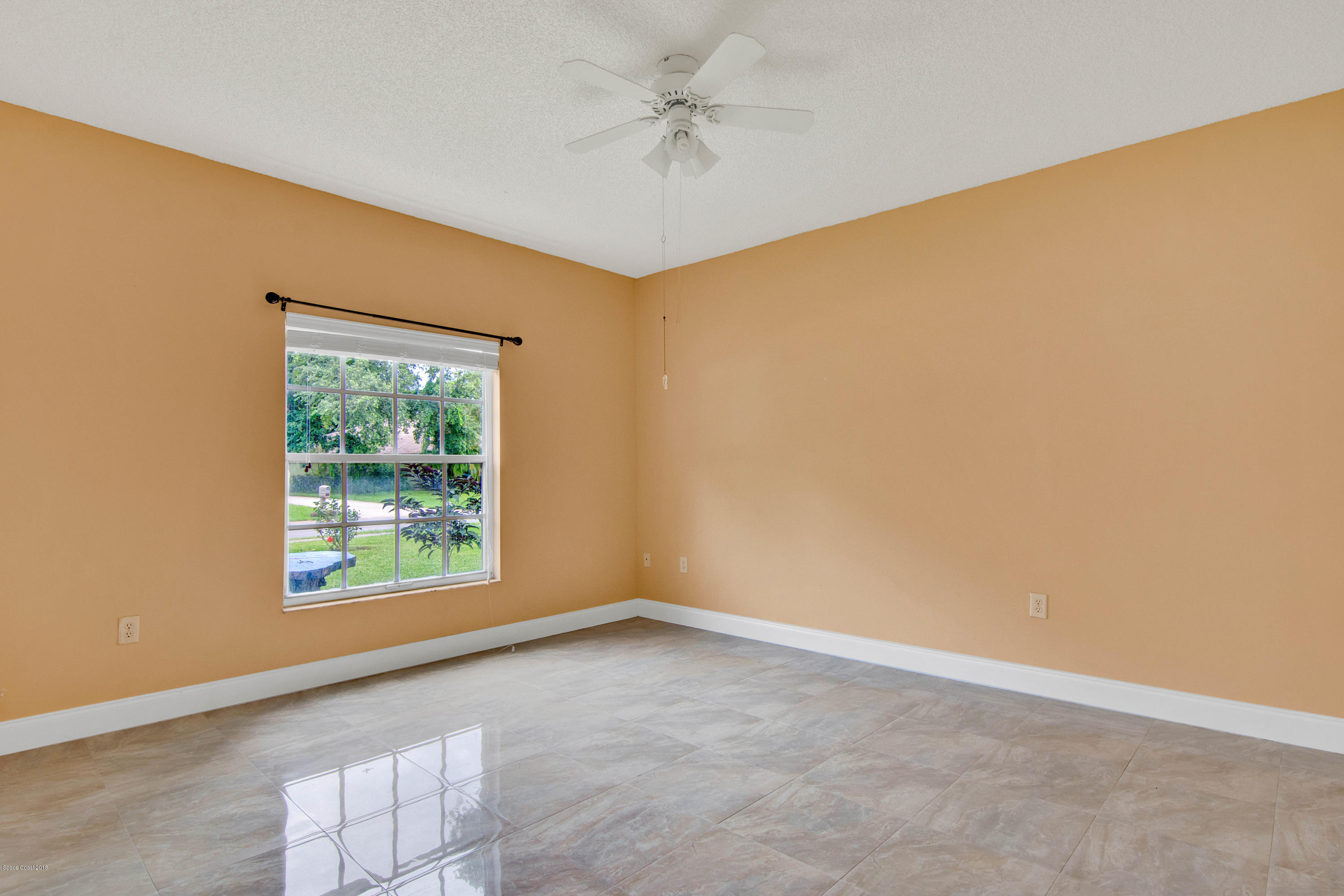 1030 Meadowbrook Road Northeast Palm Bay, FL 32905 - Photo 11 of 24 an empty room with a window and a fan