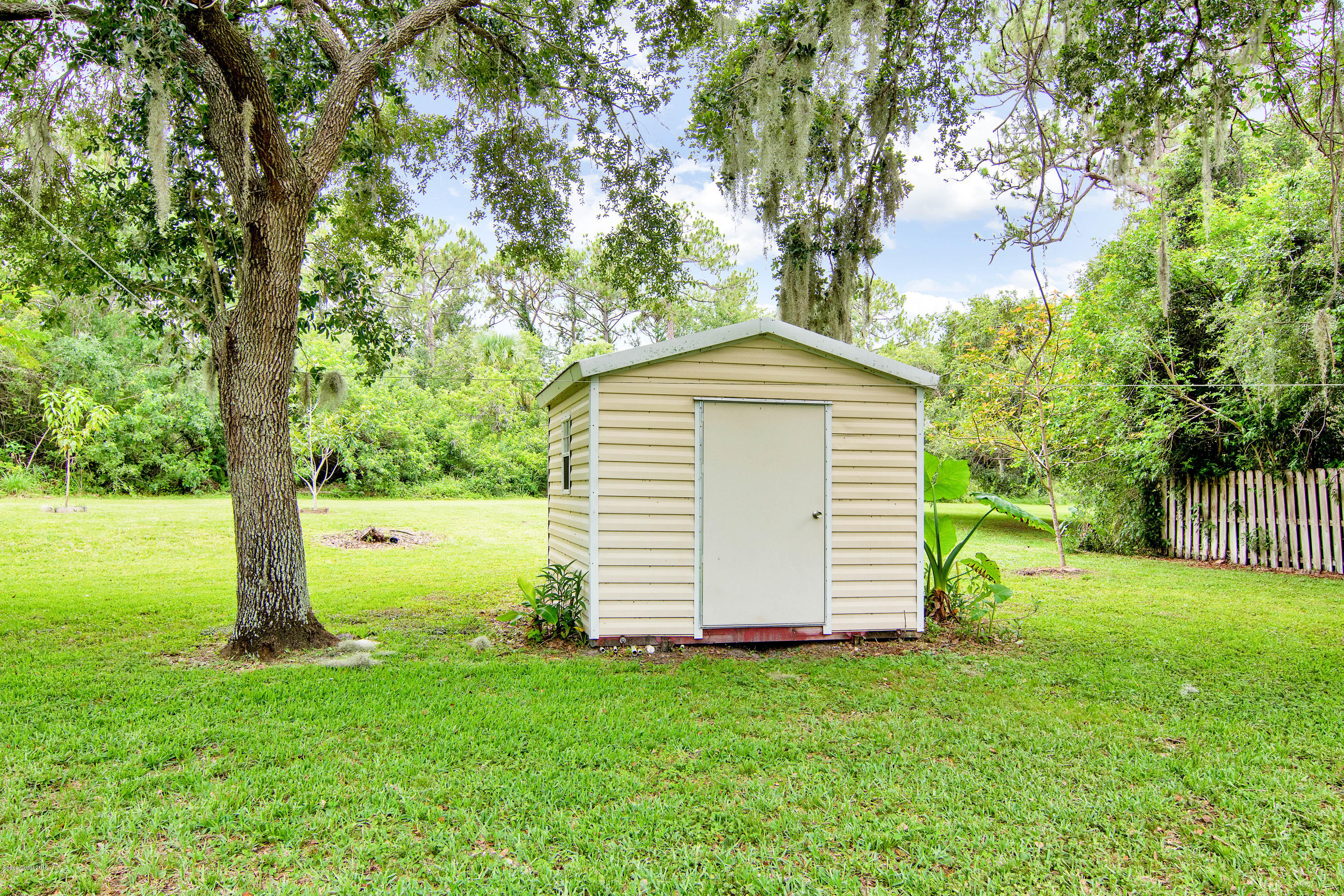 1030 Meadowbrook Road Northeast Palm Bay, FL 32905 - Photo 22 of 24 a view of a backyard with a garden and large trees