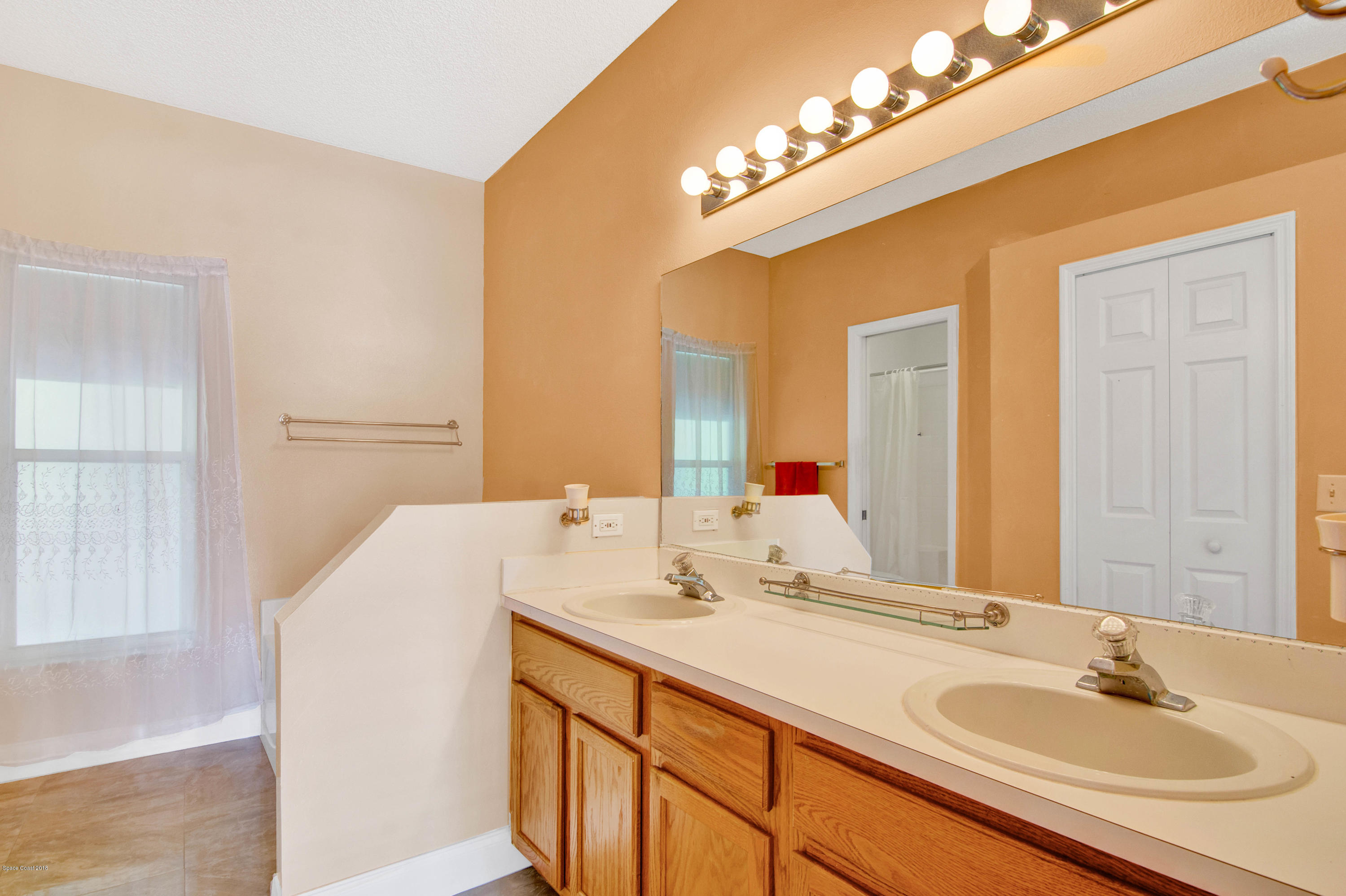 1030 Meadowbrook Road Northeast Palm Bay, FL 32905 - Photo 4 of 24 a bathroom with a sink and a mirror