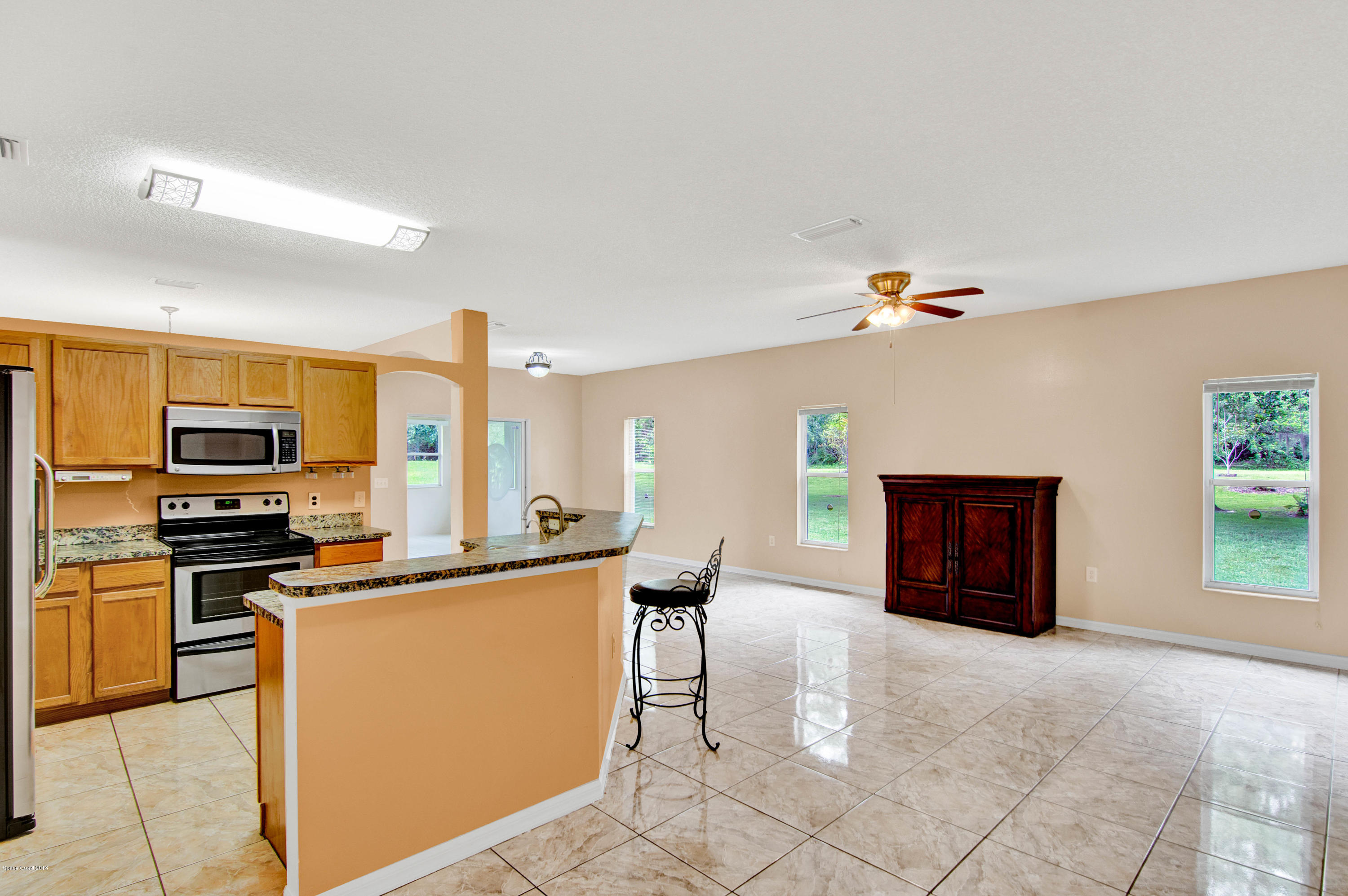 1030 Meadowbrook Road Northeast Palm Bay, FL 32905 - Photo 8 of 24 a kitchen with stainless steel appliances a stove a sink refrigerator and a stove
