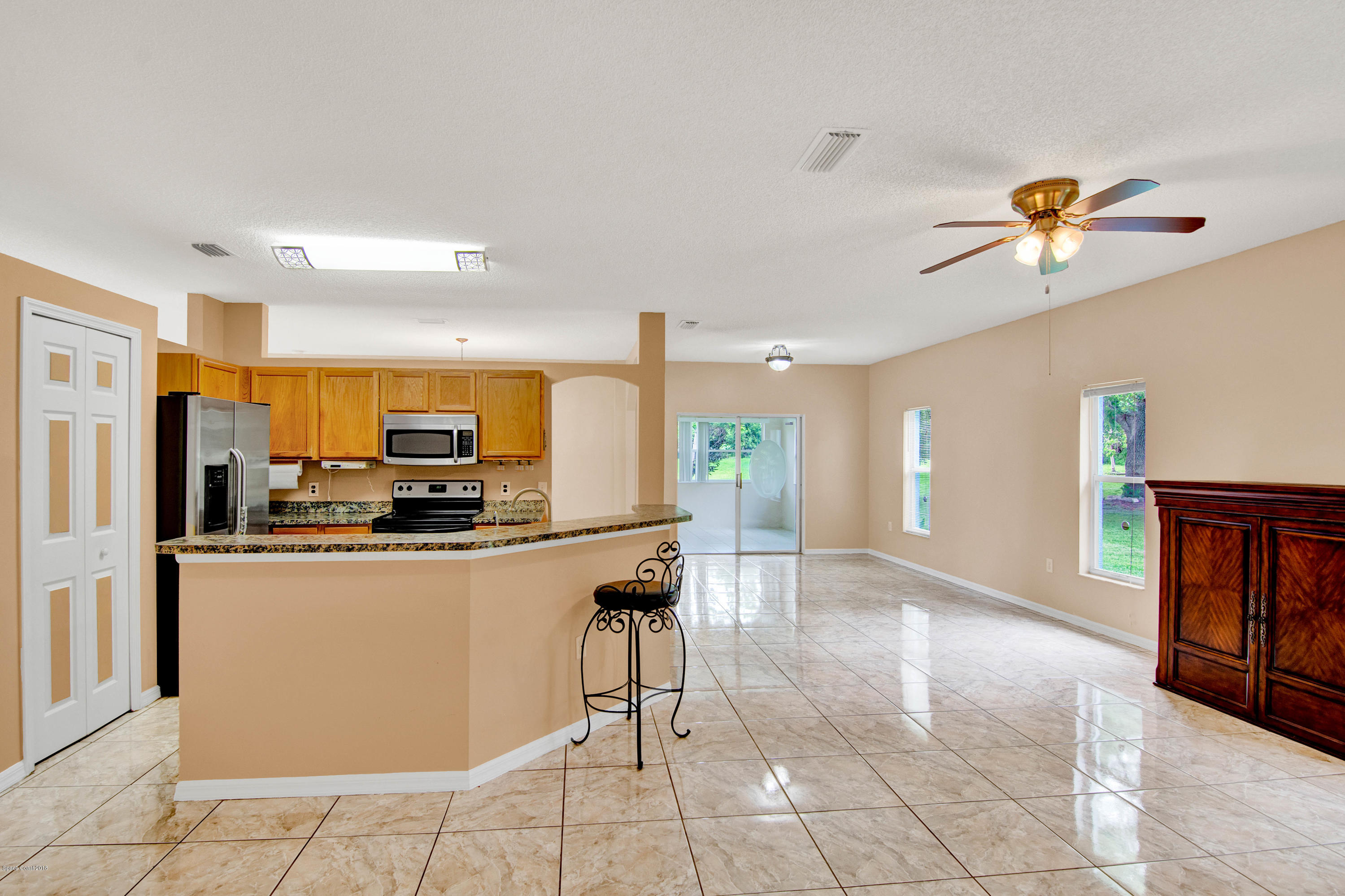 1030 Meadowbrook Road Northeast Palm Bay, FL 32905 - Photo 9 of 24 a kitchen with stainless steel appliances a refrigerator a stove top oven and a sink
